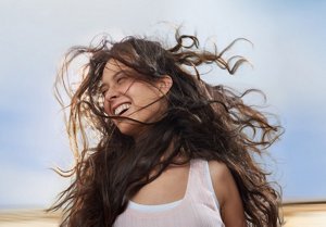 Brunette woman with wavy hair having fun outdoors